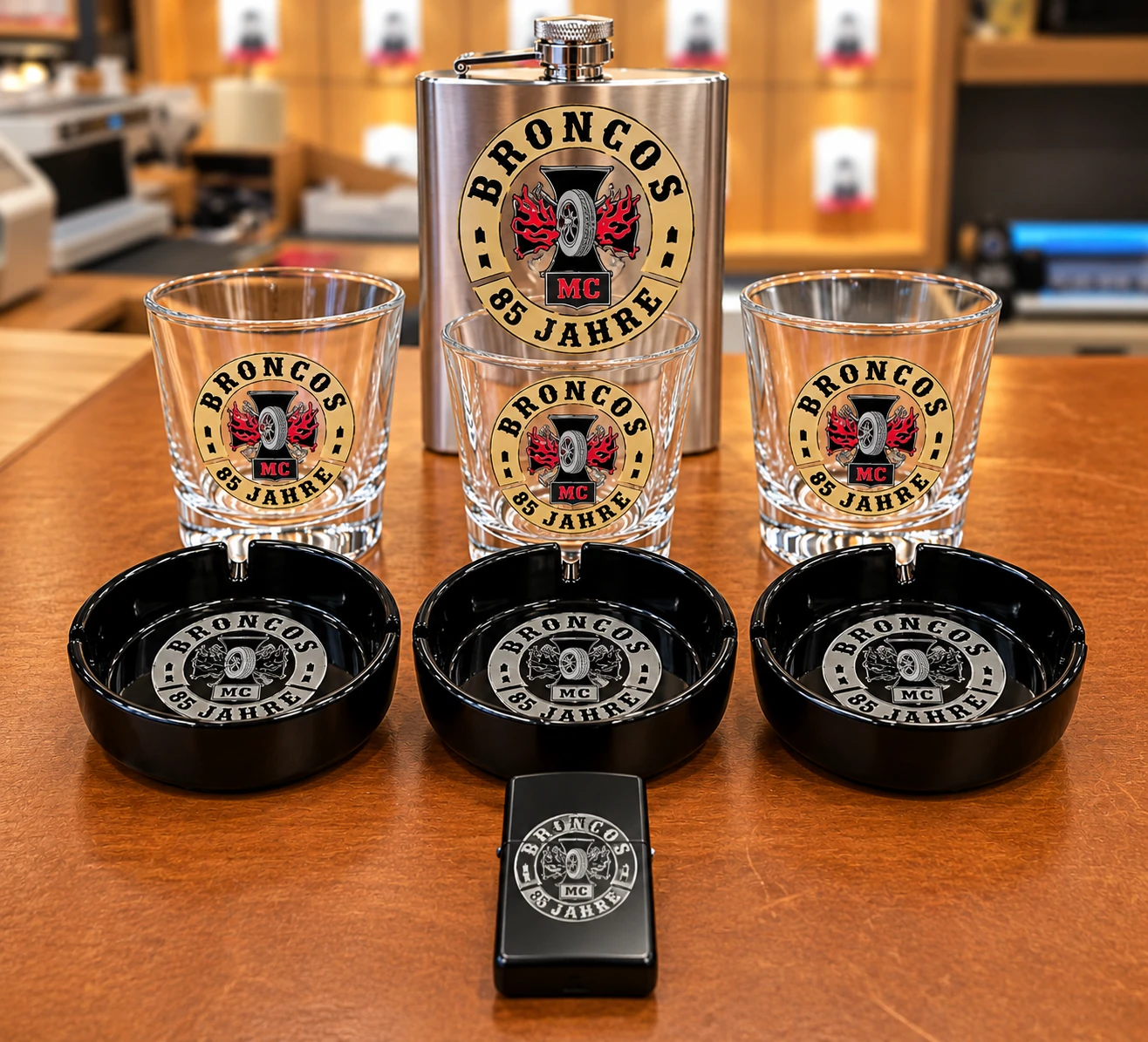 Personalisiertes Set aus Flachmann, Gläsern, Aschenbechern und Feuerzeug mit einheitlichem Motiv